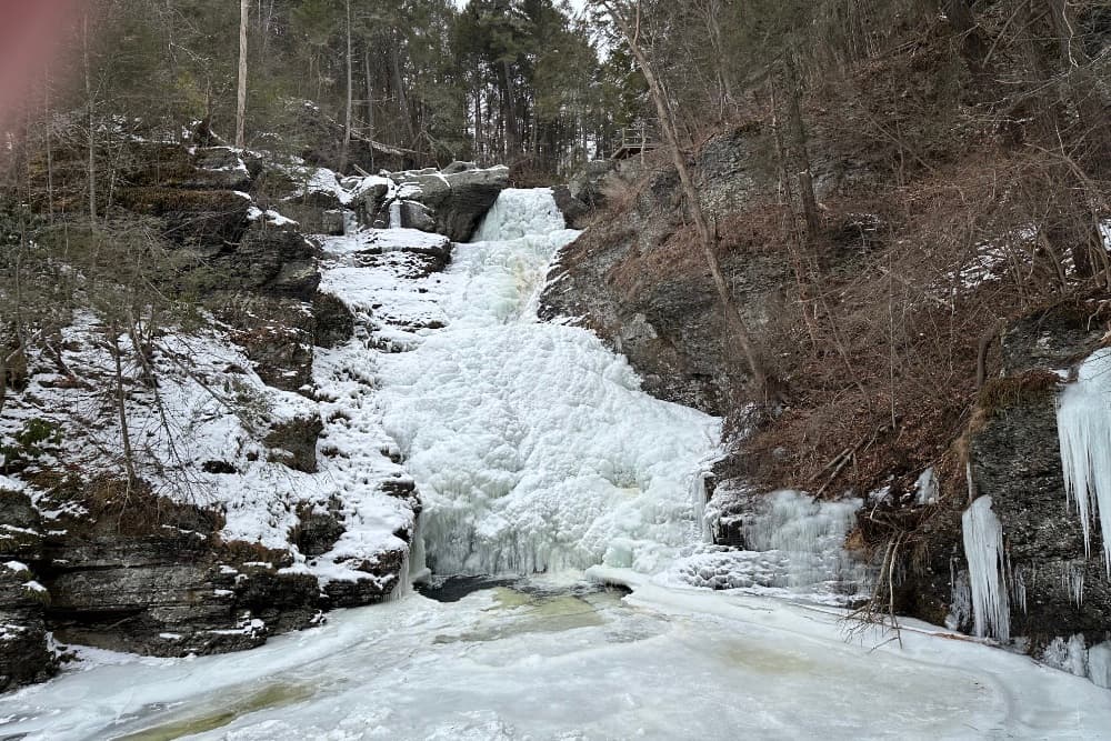 Frozen waterfall surrounded by snow and ice.