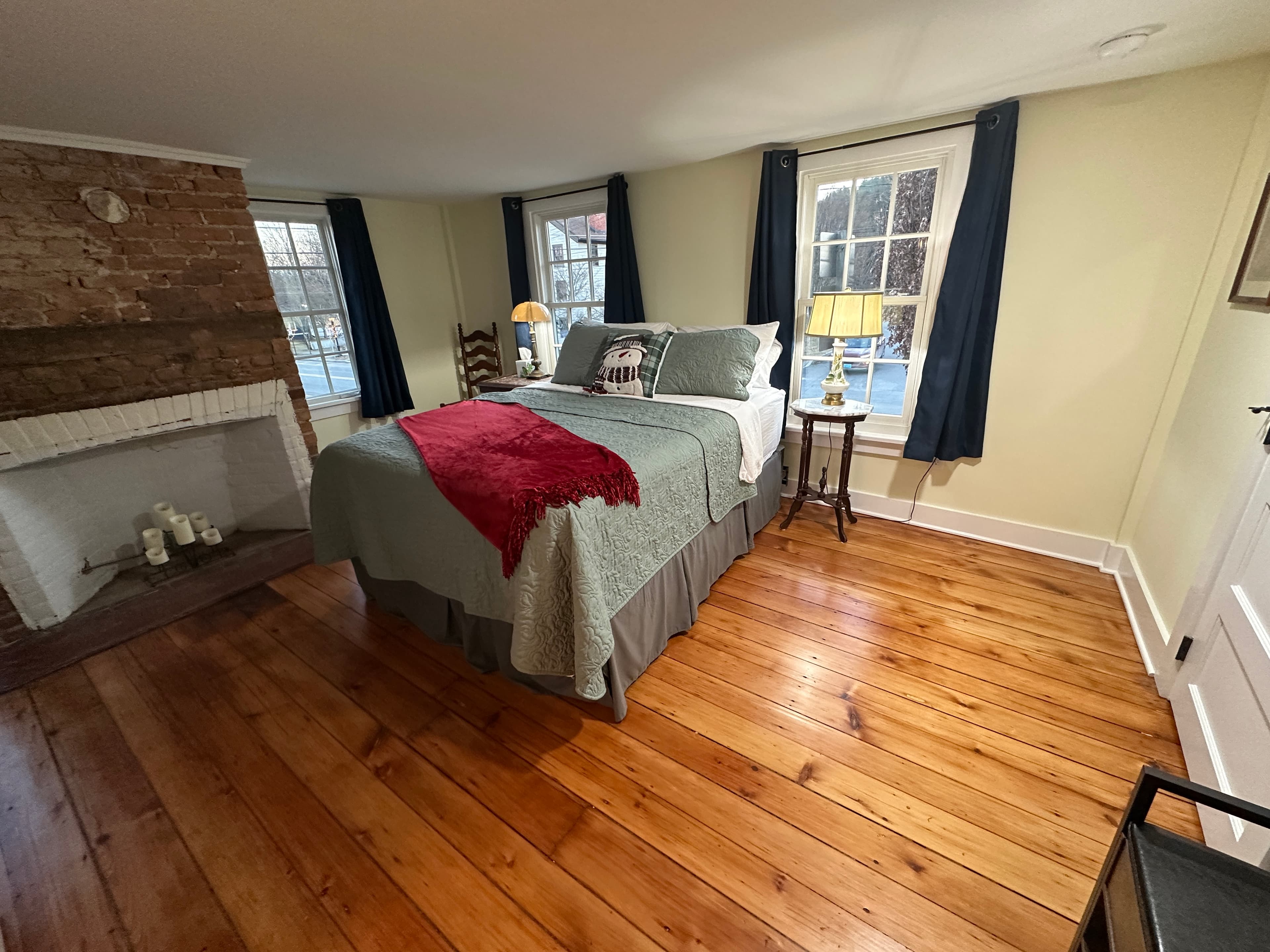 Bedroom with queen bed, sunny windows, and 200 year old hardwood floors