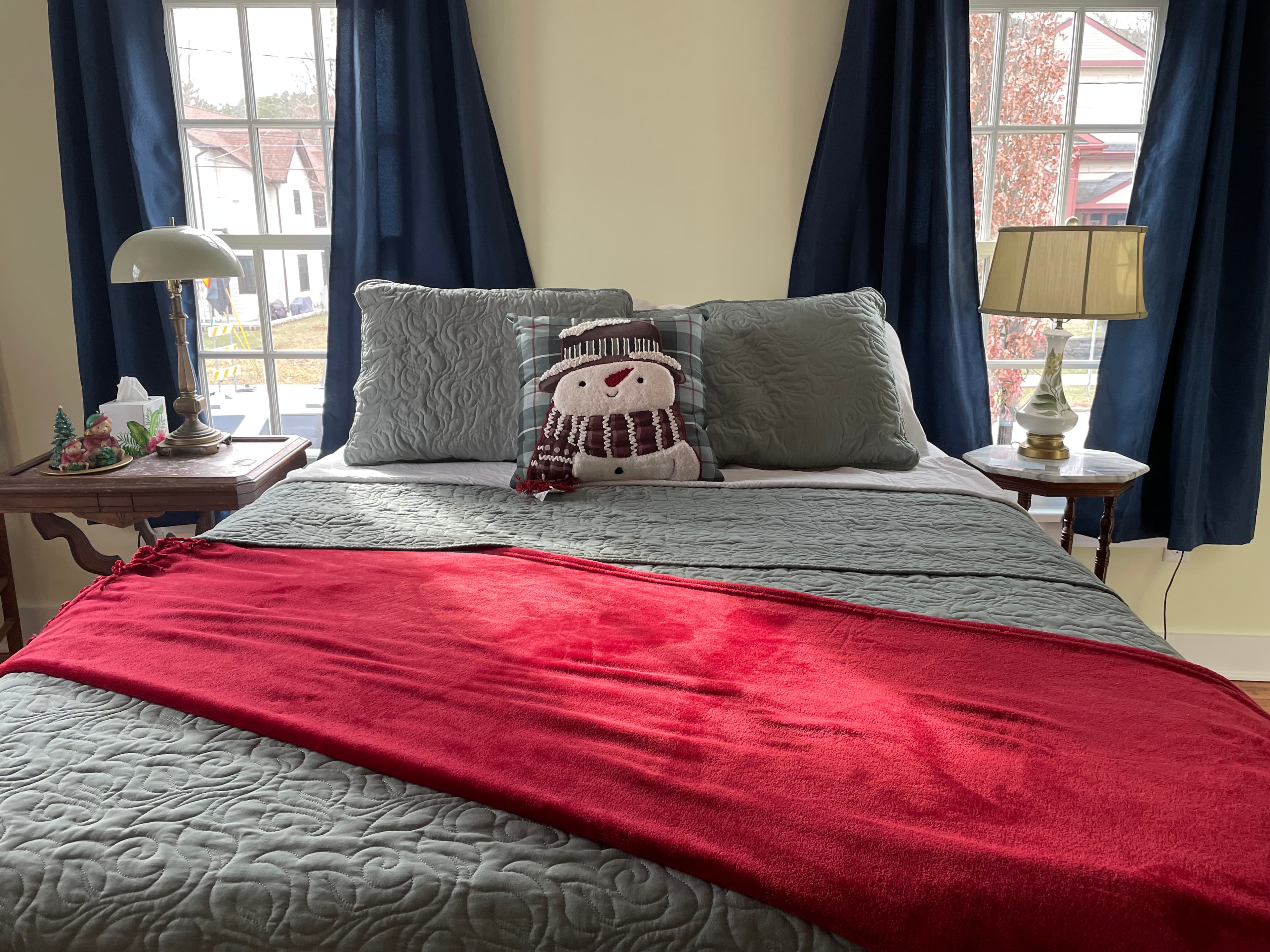 Cozy pillowtop queen bed flanked by sunny windows and end tables with lamps